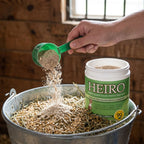 Heiro™,"Green tub beside feed bucket with scoop pouring powder"