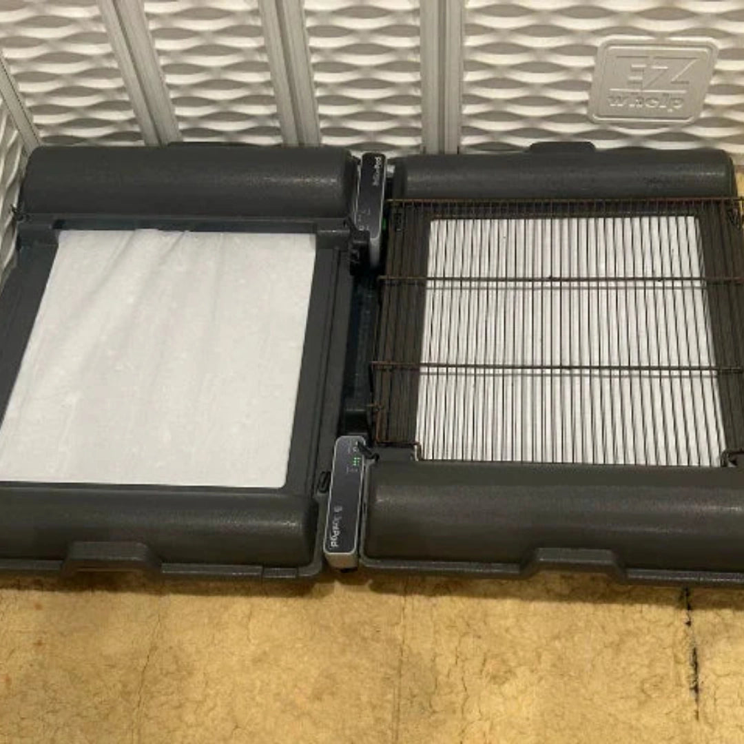BrilliantPad Grate,"Two black trays opened with white absorbent pads and wire grate insert"