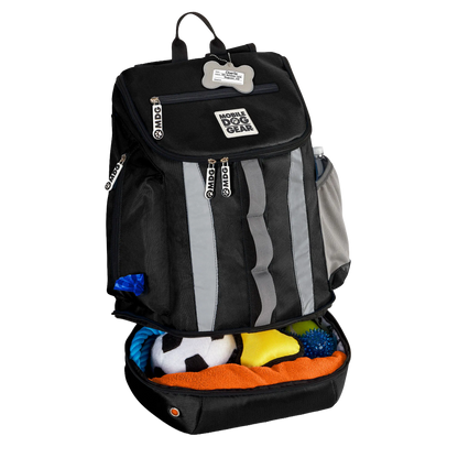Drop Bottom Week Away Backpack,"Black backpack with open bottom compartment filled with dog toys"